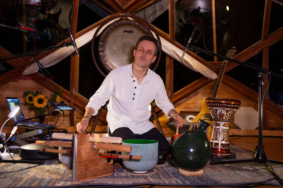 Mauro D'León entre sus cuencos de cuarzo, con el gong detrás